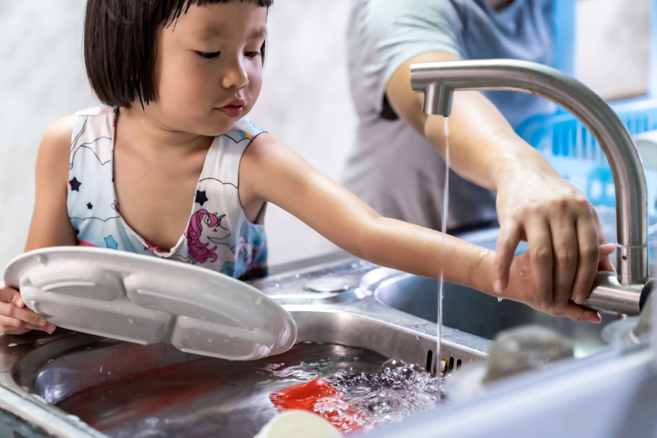 Asian girl washing dish and tableware with her mom, housework for child make executive function for kid. Houseworking for kid lifstyle and family concept.