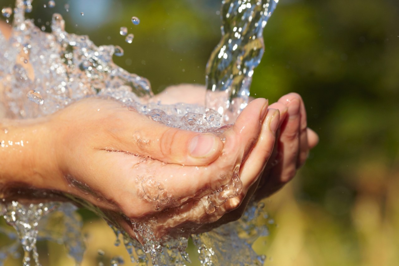 hands-holding-splashing-pure-water-with-green-background-horizontal-5616x3744-image-file-106580127