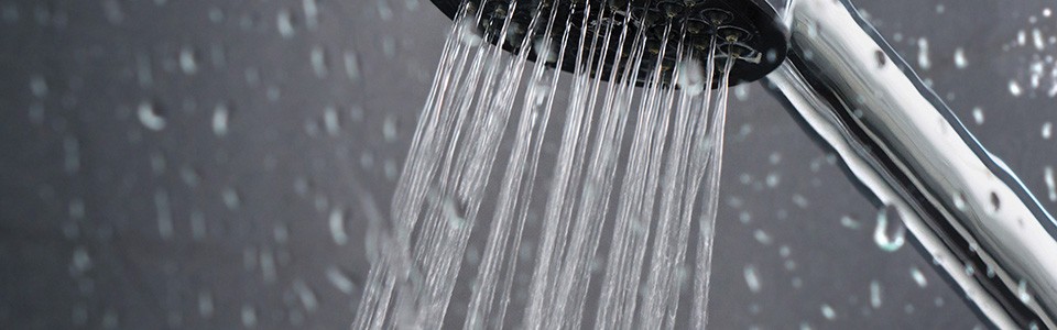 Shower spraying water with water droplets 1440x450