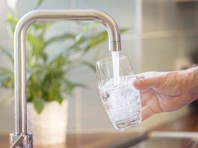 filling glass under faucet